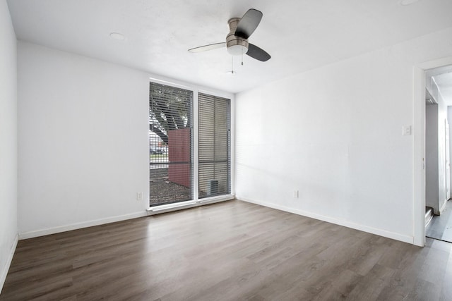 empty room with ceiling fan and dark hardwood / wood-style flooring