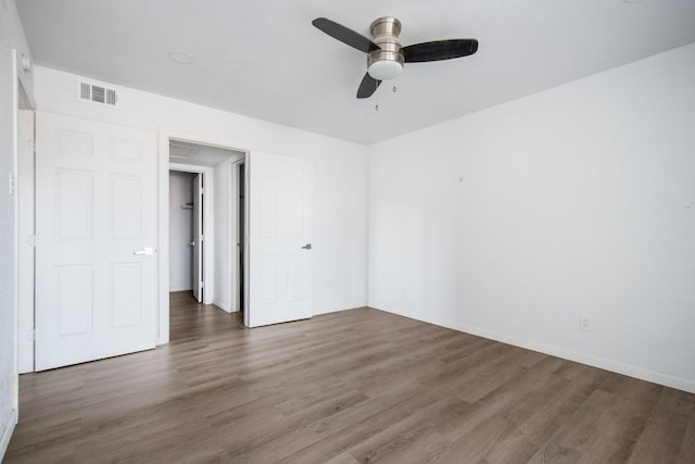 empty room with ceiling fan and dark wood-type flooring