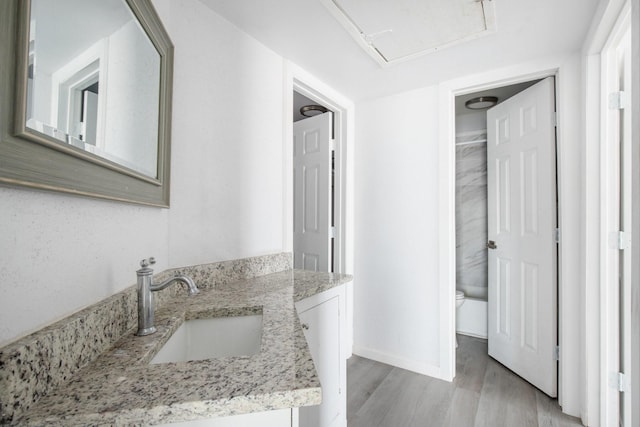 bathroom featuring toilet, vanity, and hardwood / wood-style flooring