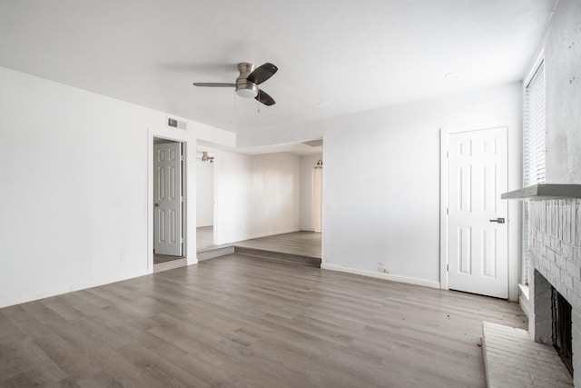 unfurnished living room with ceiling fan, hardwood / wood-style floors, and a fireplace