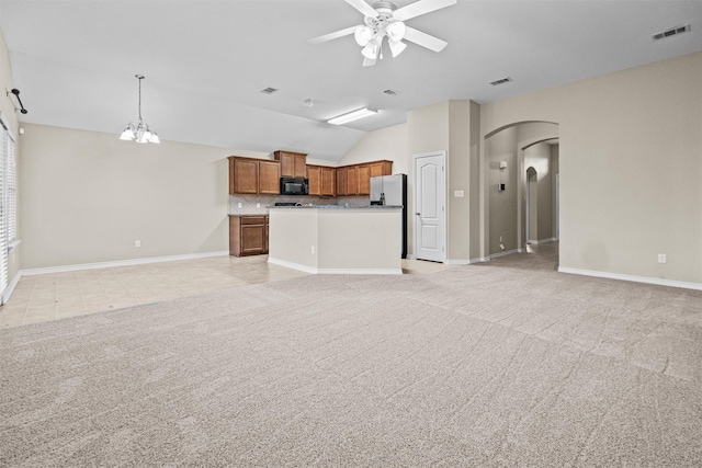 kitchen featuring visible vents, light colored carpet, brown cabinets, open floor plan, and black microwave