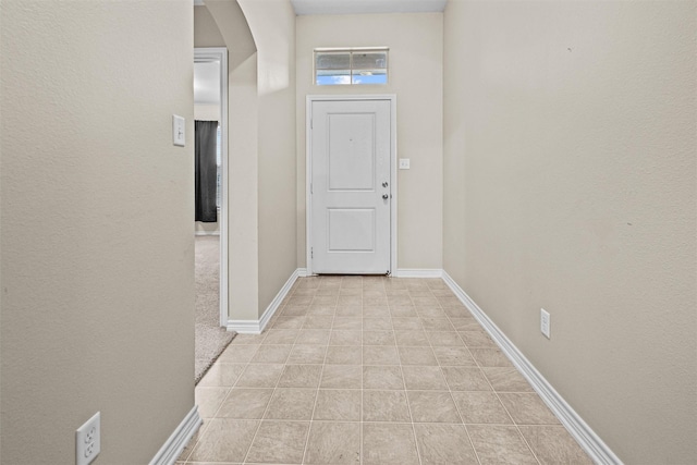 interior space featuring arched walkways and baseboards