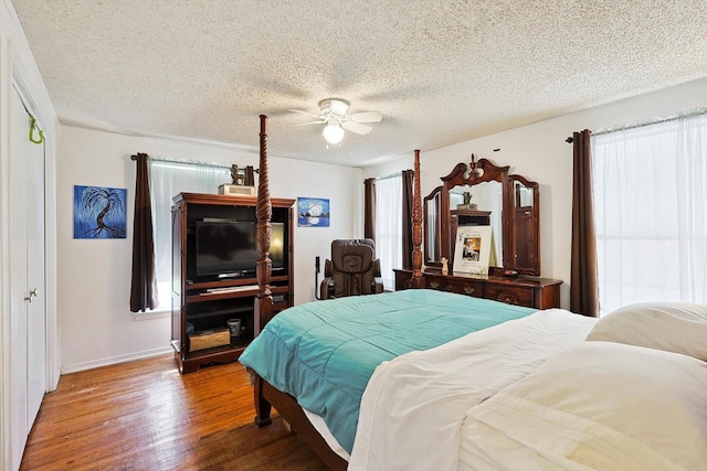 bedroom with ceiling fan, hardwood / wood-style floors, and a textured ceiling