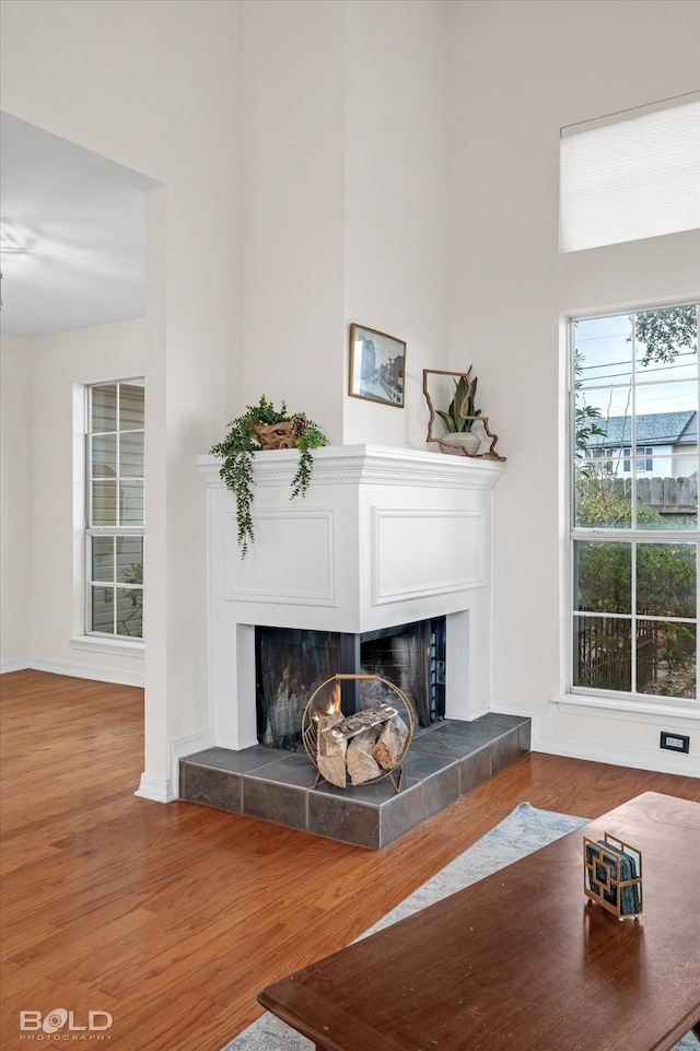 living room with hardwood / wood-style floors and a tiled fireplace