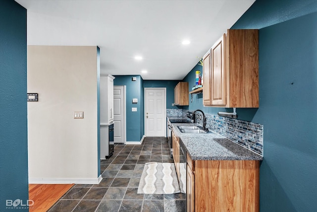 kitchen featuring backsplash, sink, dark stone countertops, and stainless steel appliances