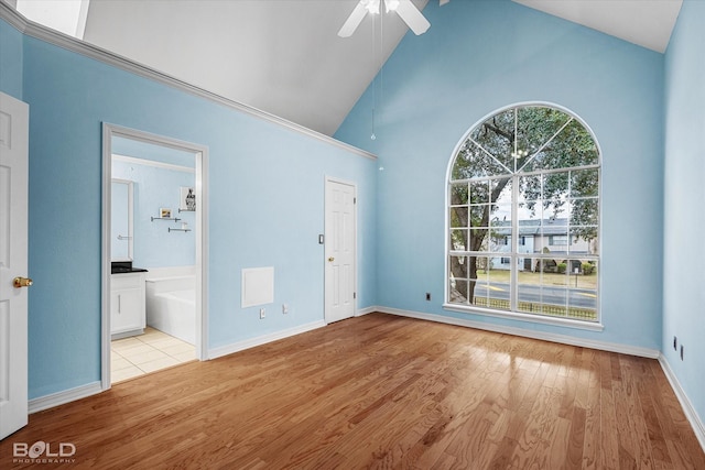 interior space featuring ceiling fan, light wood-type flooring, and high vaulted ceiling