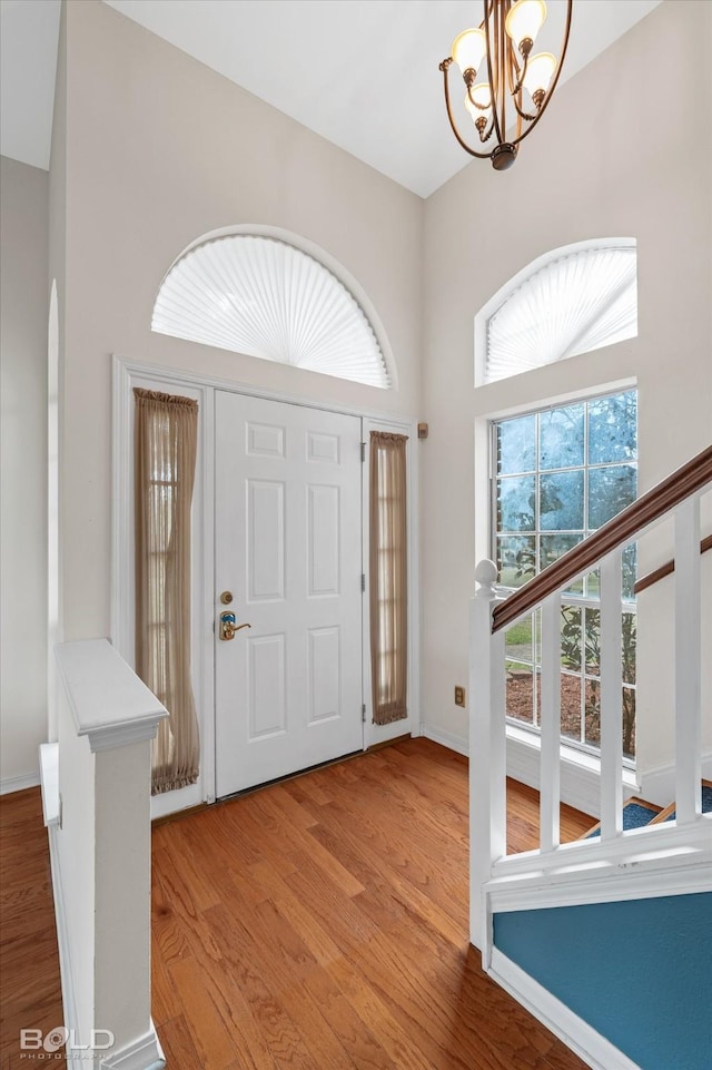 entrance foyer featuring a high ceiling, hardwood / wood-style floors, and a chandelier