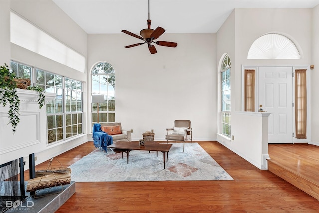 foyer featuring ceiling fan, a towering ceiling, and hardwood / wood-style flooring