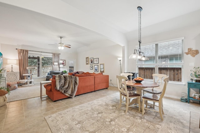 tiled dining space with ceiling fan with notable chandelier