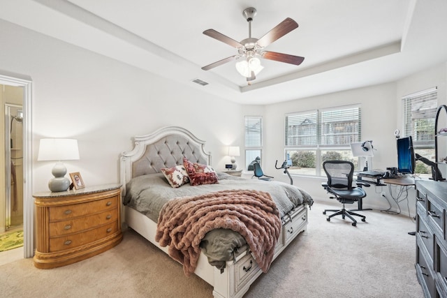 carpeted bedroom featuring ceiling fan and a tray ceiling