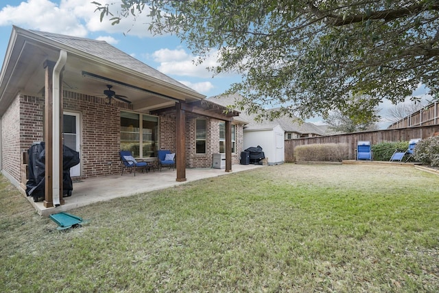 view of yard with ceiling fan, a patio area, and a shed