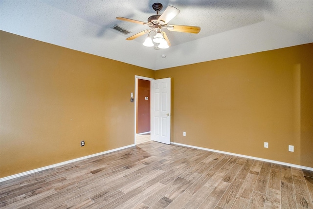 empty room with ceiling fan, light hardwood / wood-style flooring, and a textured ceiling