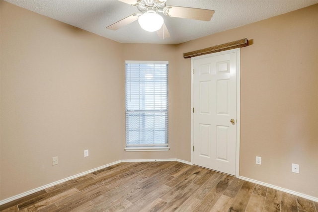 empty room featuring ceiling fan, a textured ceiling, and light wood-type flooring