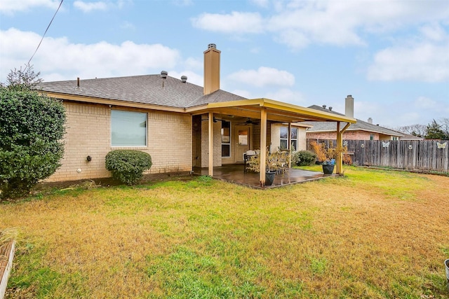 rear view of property with a lawn, ceiling fan, and a patio area