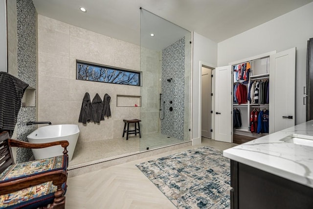 bathroom featuring plus walk in shower, parquet floors, tile walls, and vanity