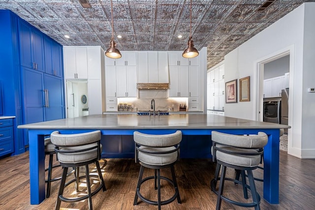 kitchen featuring hanging light fixtures, white cabinets, and a spacious island