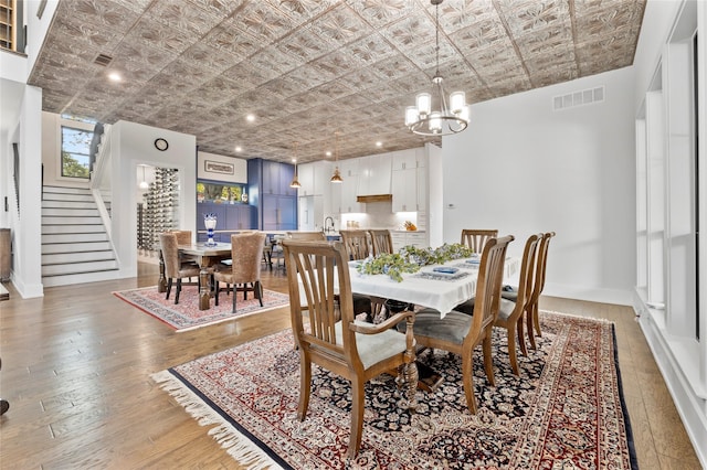 4737 Sugar Mill Rd, Dallas, TX 75244 - dining room with stairway, visible vents, an inviting chandelier, an ornate ceiling, and light wood-type flooring