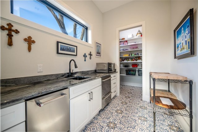 kitchen featuring white cabinets, sink, appliances with stainless steel finishes, and dark stone countertops