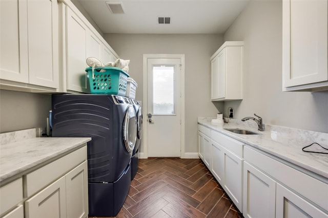 laundry room with cabinets, sink, dark parquet floors, and washing machine and clothes dryer