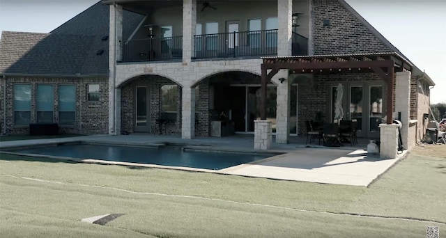 back of property with a balcony and a patio