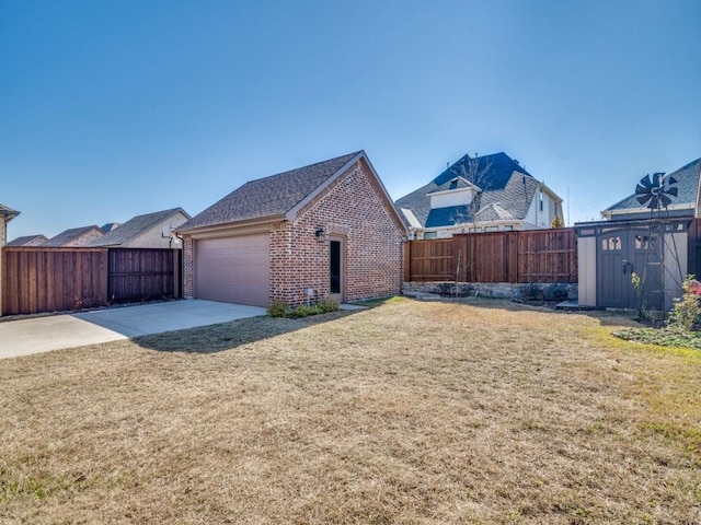 view of side of property featuring a garage, a lawn, and a storage unit