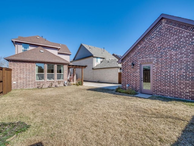 rear view of property featuring a lawn, a patio area, and a pergola