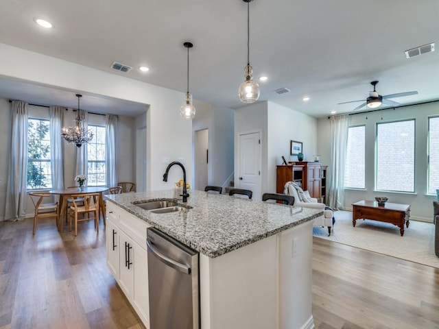 kitchen with sink, dishwasher, pendant lighting, a kitchen island with sink, and white cabinets