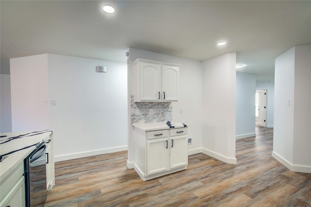 kitchen with backsplash, light hardwood / wood-style floors, beverage cooler, and white cabinets