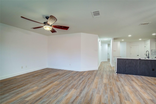 unfurnished living room featuring light hardwood / wood-style floors and ceiling fan