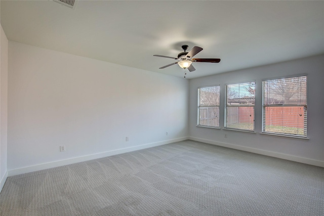 carpeted spare room featuring ceiling fan