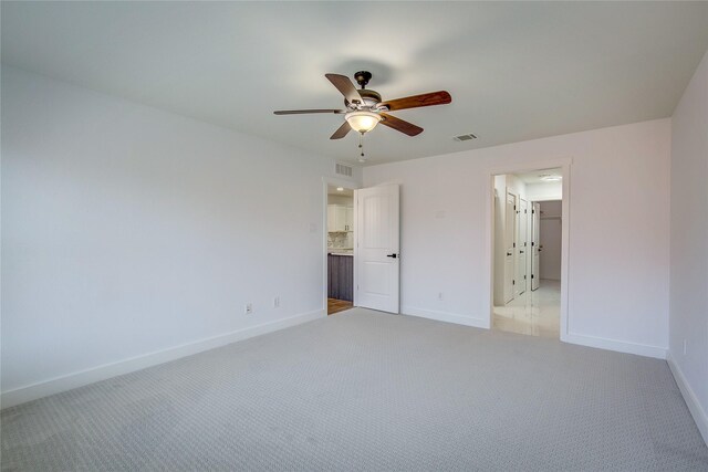 unfurnished bedroom featuring ceiling fan and light carpet