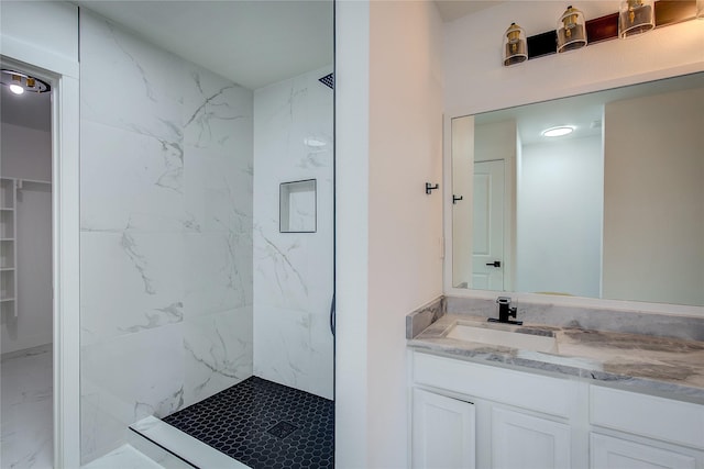 bathroom featuring a tile shower and vanity