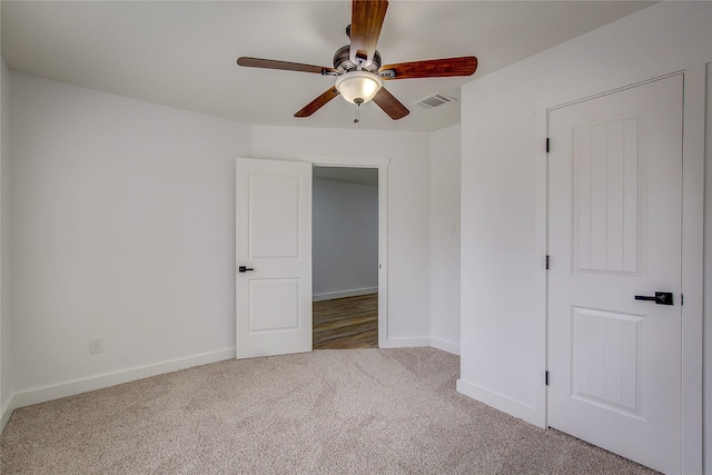 carpeted spare room featuring ceiling fan