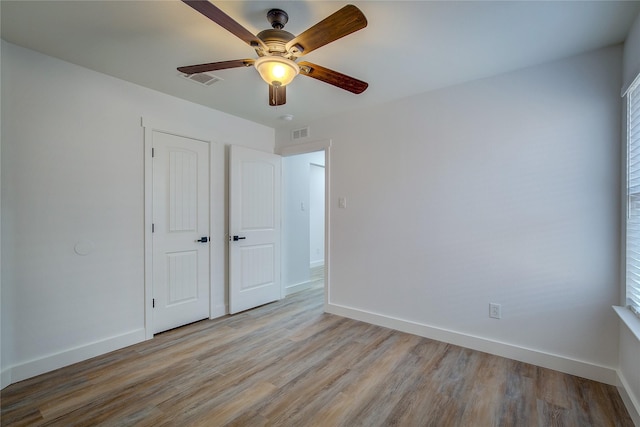 unfurnished bedroom featuring light hardwood / wood-style floors, a closet, and ceiling fan