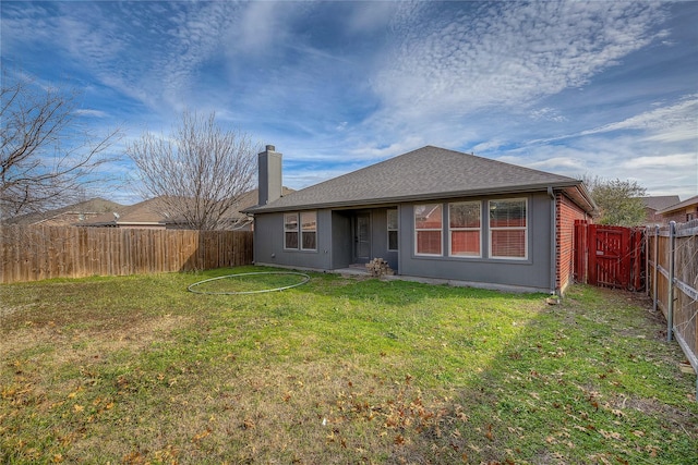 rear view of house with a yard