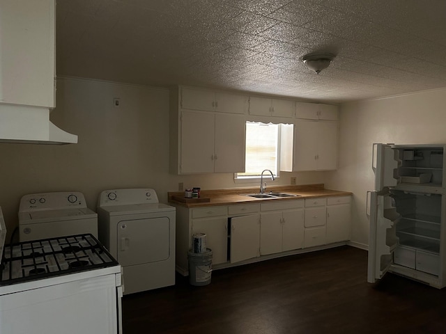 kitchen featuring white cabinetry, washer and clothes dryer, dark hardwood / wood-style flooring, and sink