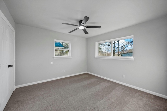 carpeted spare room featuring ceiling fan