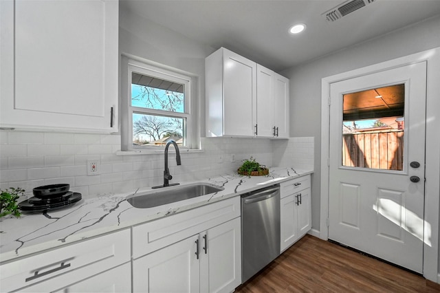 kitchen with dishwasher, sink, white cabinets, tasteful backsplash, and light stone countertops