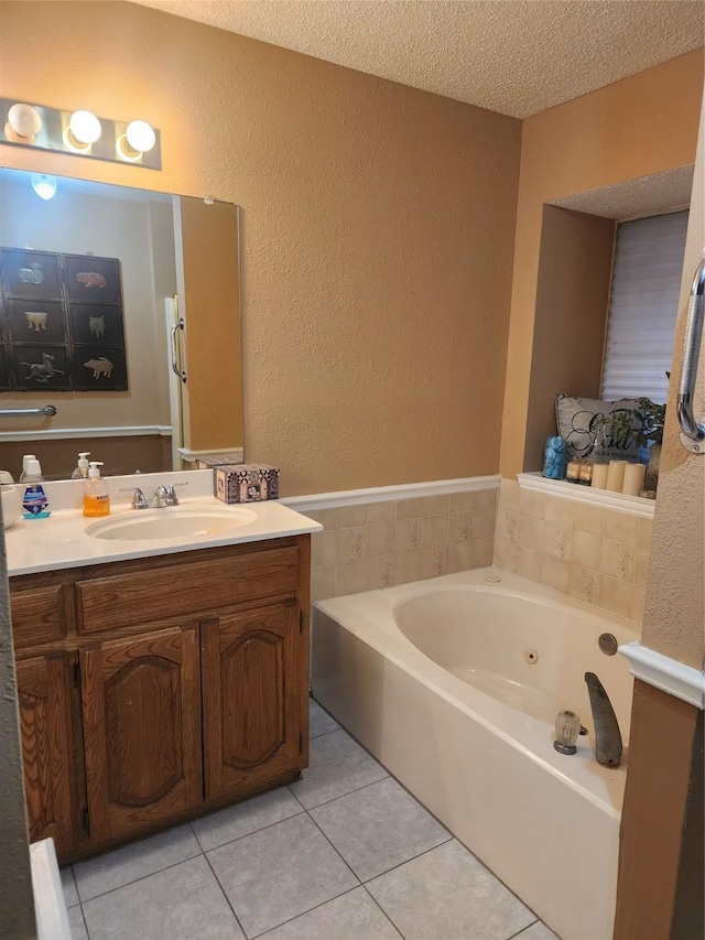 bathroom with a washtub, a textured ceiling, vanity, and tile patterned flooring