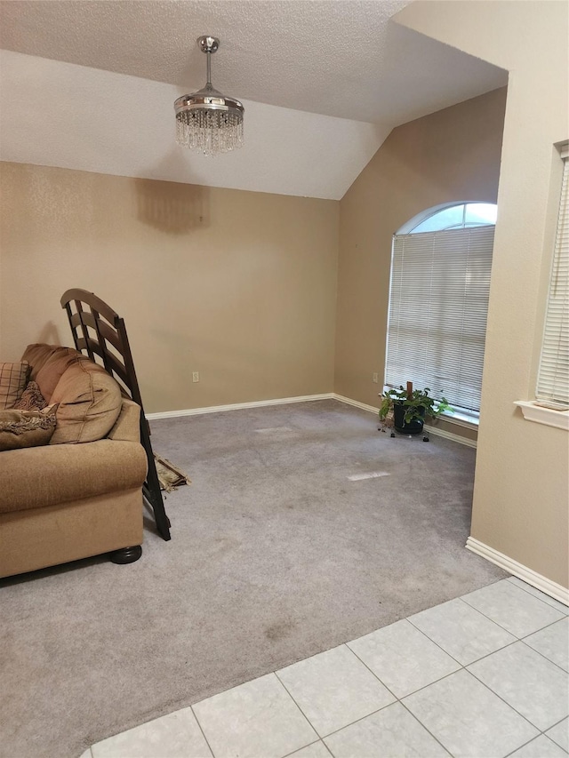 living area with light colored carpet, a textured ceiling, vaulted ceiling, and an inviting chandelier