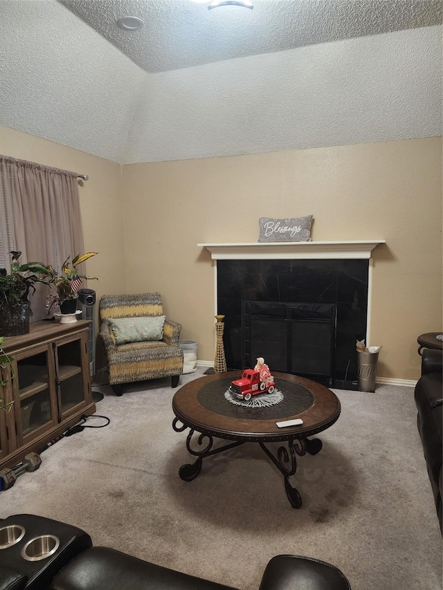 living room with carpet, vaulted ceiling, a tile fireplace, and a textured ceiling