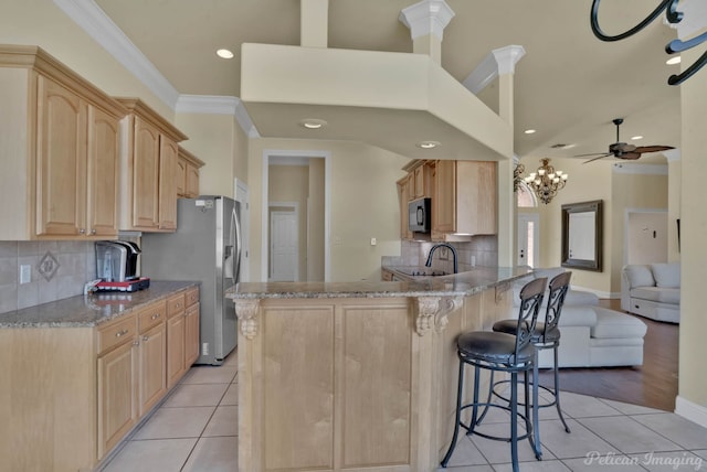 48 Turnbury Dr, Bossier City, LA 71111 - kitchen with light brown cabinetry, light stone countertops, a breakfast bar, light tile patterned floors, and kitchen peninsula