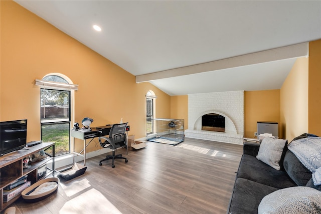 office space with lofted ceiling with beams, a fireplace, and hardwood / wood-style flooring