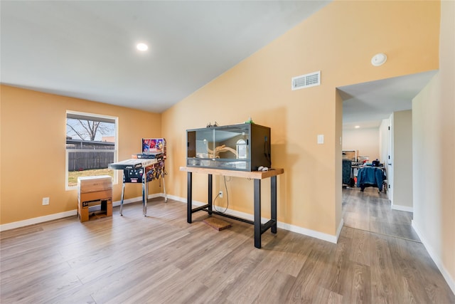 misc room with light hardwood / wood-style floors and high vaulted ceiling