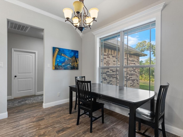 dining room featuring dark wood-type flooring, a chandelier, and ornamental molding