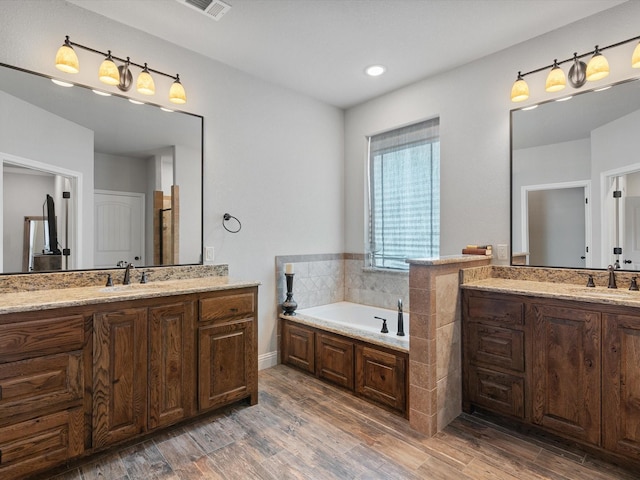 bathroom with vanity, a bath, and hardwood / wood-style flooring