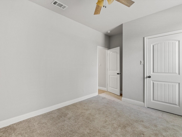 spare room featuring ceiling fan and light colored carpet