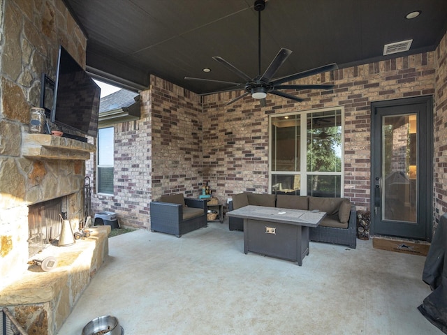 view of patio with ceiling fan and an outdoor living space with a fireplace