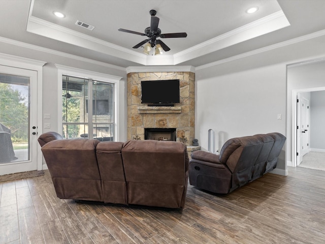 living room featuring a raised ceiling, ceiling fan, dark hardwood / wood-style floors, and crown molding