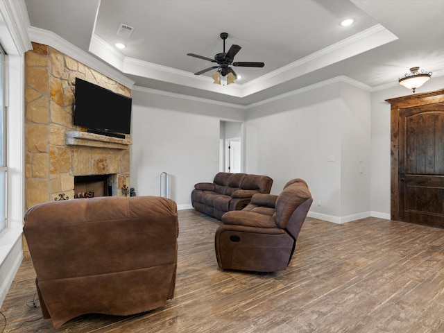 living room with ceiling fan, a raised ceiling, crown molding, and hardwood / wood-style flooring